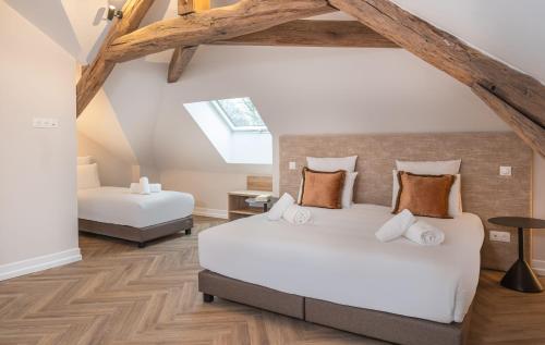 a attic bedroom with two beds and a skylight at L'Horloge - Appart'Hotel proche de Disneyland in Montévrain