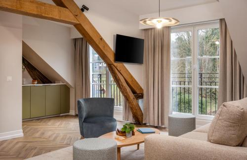a living room with a couch and a table at L'Horloge - Appart'Hotel proche de Disneyland in Montévrain