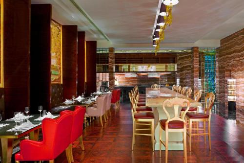 a dining room with tables and red chairs at Sheraton Chongqing Hotel in Chongqing