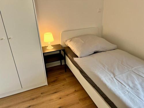a small bedroom with a bed and a lamp on a night stand at Monteur- und Ferienwohnung Lingenfeld in Lingenfeld