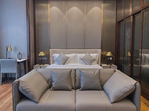 a bedroom with a bed and a couch with pillows at Roosevelt Service Apartment Chongqing Jiefangbei Pedestrian Street Hongyadong Branch in Chongqing