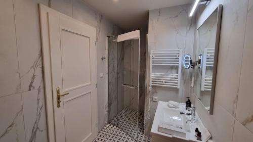 a white bathroom with a sink and a mirror at Hotel Savoy Prague in Prague