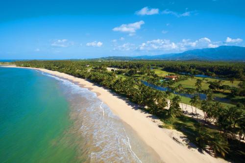 an aerial view of a beach with palm trees and the ocean at St. Regis Bahia Beach Resort, Puerto Rico in Rio Grande
