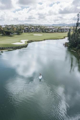 a person in a boat in the water next to a golf course at St. Regis Bahia Beach Resort, Puerto Rico in Rio Grande