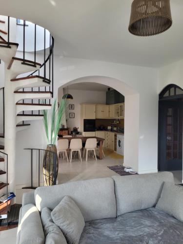 a living room with a couch and a spiral staircase at Casa branca in Porto Carvoeiro