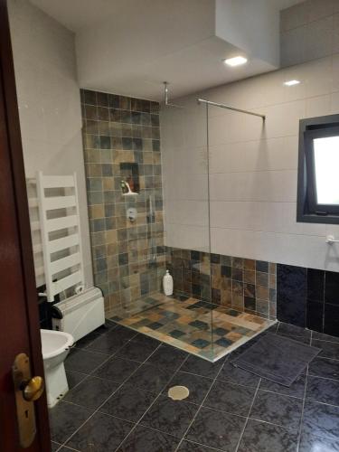 a bathroom with a shower with a toilet and a television at Casa branca in Porto Carvoeiro
