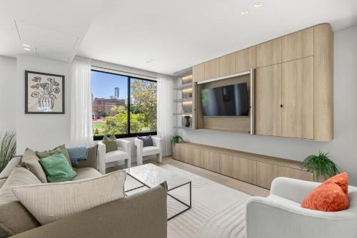 a living room with a couch and a tv at Perfect Vacation Home w Terrace & Private Garage in Sydney