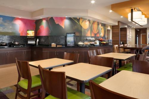 a restaurant with tables and chairs and a bar at Fairfield Inn & Suites Youngstown Boardman Poland in Poland