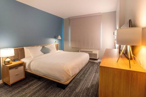 a bedroom with a bed and a table with a lamp at TownePlace Suites by Marriott Conroe in Conroe