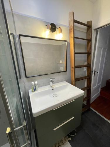 une salle de bain avec un lavabo et un miroir dans l'établissement Ty Kerf' proche centre, cosy, à Quimper