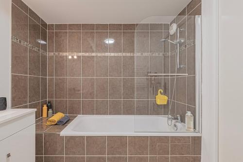une salle de bain avec baignoire et douche dans l'établissement Elegant Disney Paris apartment for 6, à Chessy