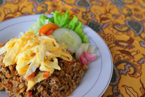 une plaque de nourriture avec du riz et des légumes sur une table dans l'établissement WARISAN Heritage Boutique Hotel, à Solo