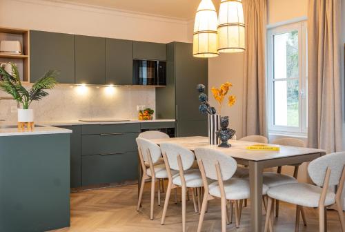 a kitchen and dining room with a table and chairs at L'Horloge - Appart'Hotel proche de Disneyland in Montévrain