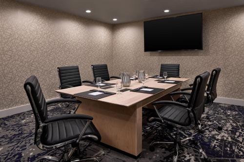 a conference room with a large table and a flat screen tv at Sheraton Richmond Airport Hotel in Sandston