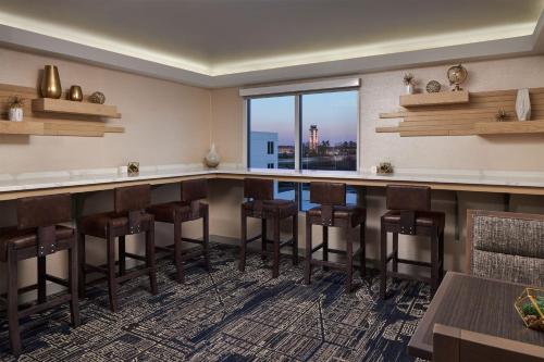 a bar in a restaurant with a view of the city at Sheraton Richmond Airport Hotel in Sandston