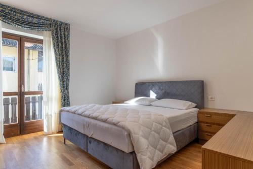 a bedroom with a bed and a large window at Dimora Svaizer, Terzolas Ospitar in Terzolas