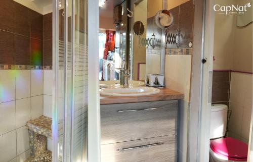 une salle de bain avec un lavabo et un miroir dans l'établissement CapNat - Village Naturiste - Port Nature - Villa Marrakech, au Cap d'Agde