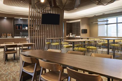 a restaurant with tables and chairs and a flat screen tv at SpringHill Suites by Marriott Orlando Lake Nona in Orlando