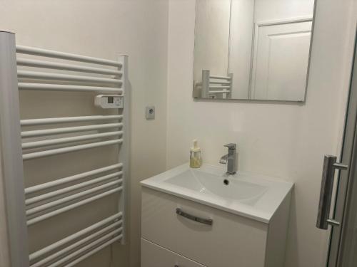 une salle de bain blanche avec un lavabo et un miroir dans l'établissement Le Coin Du Soleil, à Toulon