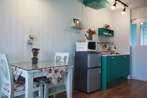 a small kitchen with a table and a microwave at Pyeongchang Edelweiss Pension in Pyeongchang 