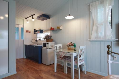 a kitchen with a table and a sink and a microwave at Pyeongchang Edelweiss Pension in Pyeongchang 