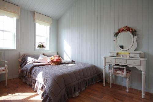 a bedroom with a bed and a table with a mirror at Pyeongchang Edelweiss Pension in Pyeongchang 