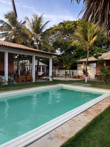 a swimming pool in front of a house at Pousada Vila Flow in Cumbuco