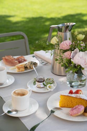 een tafel met borden eten en kopjes koffie bij Castello Di Gabbiano in Mercatale Val Di Pesa