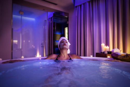 a woman in a bath tub in a room at Costa Rica Bibione SPA in Bibione