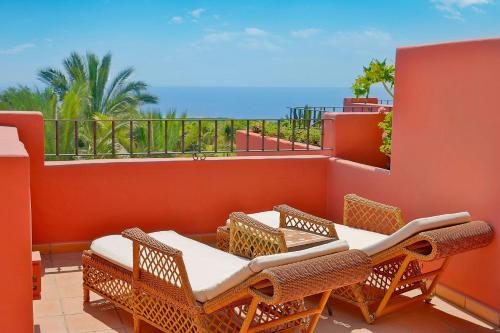 a patio with a table and chairs on a balcony at The Ritz-Carlton Tenerife, Abama in Guía de Isora
