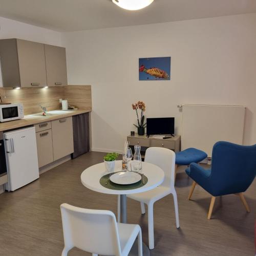 un salon avec une table et des chaises et une cuisine dans l'établissement Résidence NOVAGE - Amiens, à Amiens