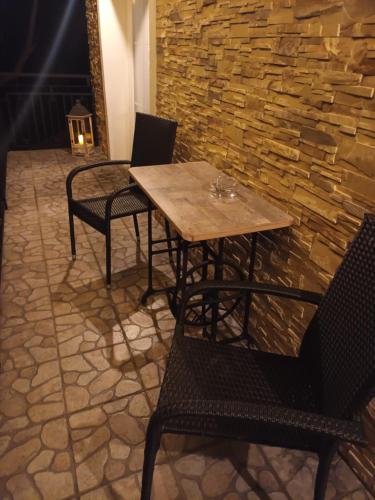 a table and chairs in front of a stone wall at Villa Evetes in Jablonov nad Turnou