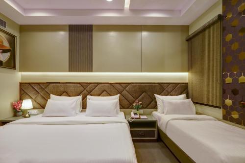 two beds in a hotel room with white pillows at The Viking Hotel- 5 Minutes away from New Delhi Railway & Connaught Place in New Delhi