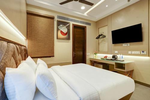 a bedroom with a white bed and a television at The Viking Hotel- 5 Minutes away from New Delhi Railway & Connaught Place in New Delhi