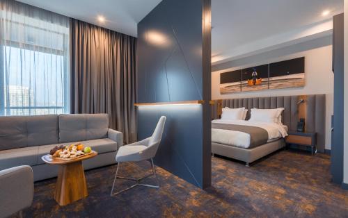 a hotel room with a couch and a bed at Onyx City Center in Tbilisi City