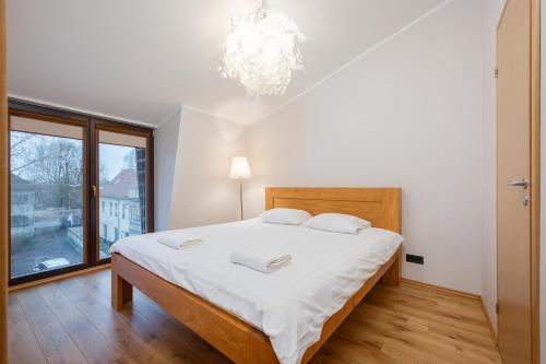 a bedroom with a large bed and a large window at Modern city center apartment in Tartu