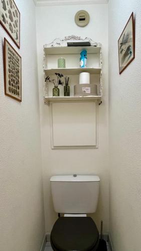 La salle de bains est pourvue de toilettes et d'étagères murales. dans l'établissement Appart CANNES résidence piscine-parc-tennis, à Cannes
