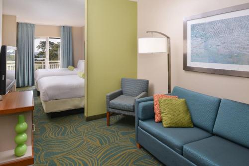 a hotel room with a couch and a bed at SpringHill Suites by Marriott Charleston Riverview in Charleston