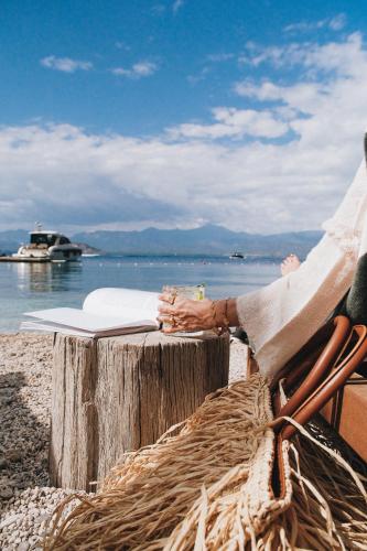 a person sitting in a chair at a table on the beach at Yazz Collective in Fethiye