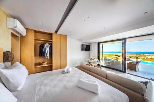 a bedroom with a large bed and a large window at Villa Kamelia with pool in Gournes