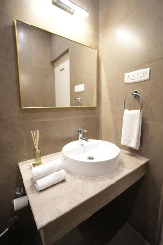 a bathroom with a sink and a mirror at Hanu Reddy Residences Poes Garden in Chennai