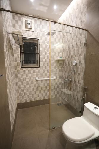 a bathroom with a glass shower with a toilet at Hanu Reddy Residences Poes Garden in Chennai