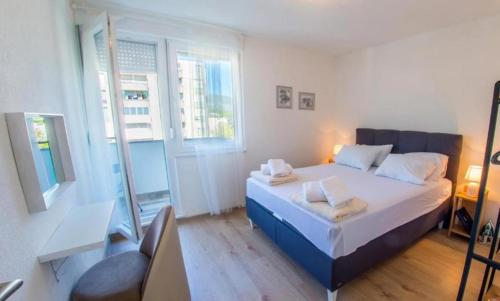 a bedroom with a bed and a desk and a window at Francis First in Mostar