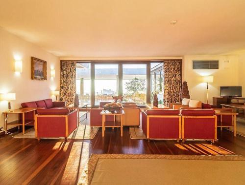 a living room with red furniture and a large window at Hotel Fortaleza de Almeida by ASITE Hotels in Almeida