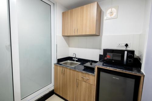 a small kitchen with a sink and a microwave at SRK Service Apartment And Hotel in Kathmandu