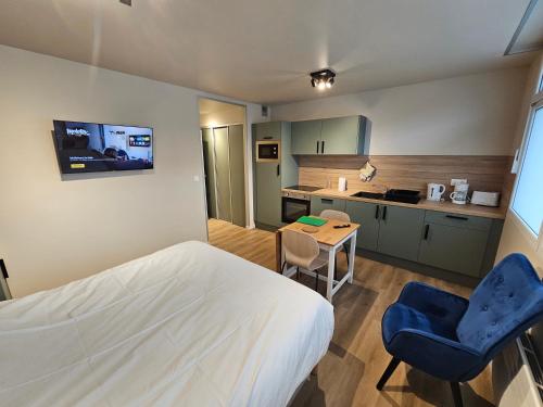 une chambre avec un lit et une table et une cuisine dans l'établissement Les Gîtes du Moulin des Loups, à Saint-Amand-les-Eaux