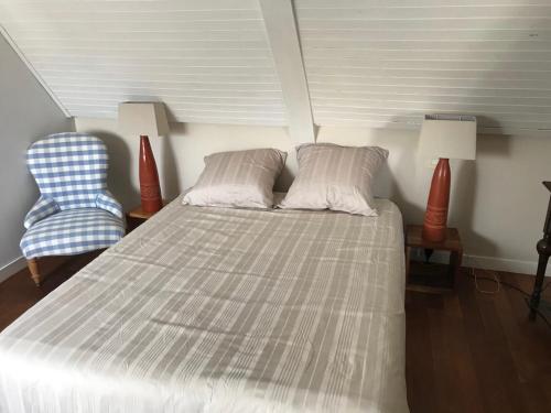 a bedroom with a bed and a blue chair at Chambres d'Hôtes Maison de Charme à Trégastel in Trégastel