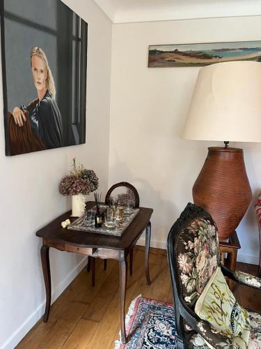 a living room with a table and a picture of a woman at Chambres d'Hôtes Maison de Charme à Trégastel in Trégastel