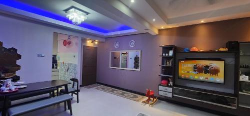 a living room with purple walls and a tv at Homestay Arysha Dhalia in Kuala Terengganu
