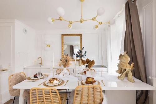 une salle à manger avec une table et des chaises blanches dans l'établissement Suite de Luxe à 10 min de Paris - Sauna, Cinéma, à Bagneux